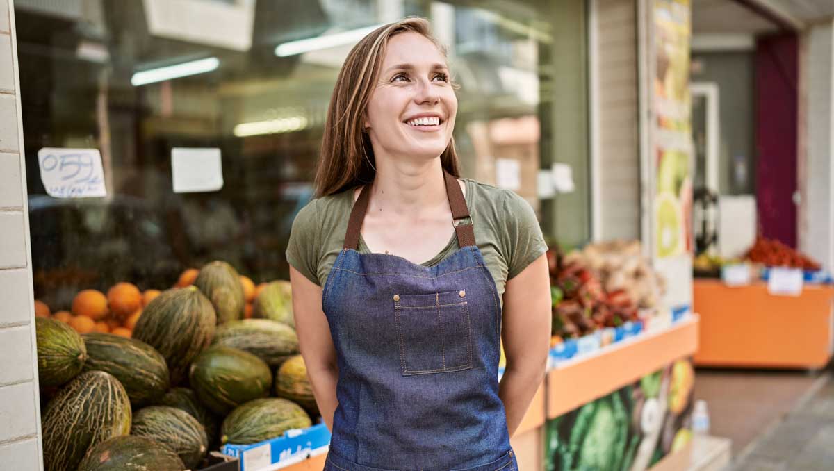 Store worker standing next to fresh produce